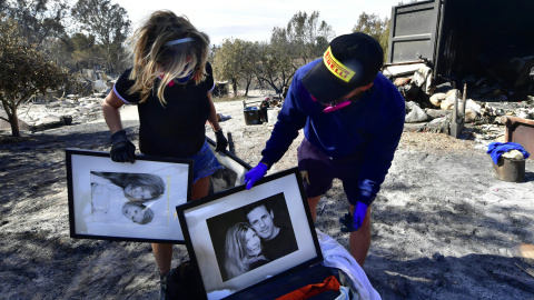 Katherine Marinara y su hijo Luca rescatan de las cenizas viejas fotografías familiares en Busch Drive, Malibu.- AFP