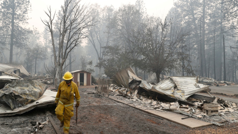 Un bombero de Cal Fire camina entre las casas destruidas por el devastador incendio en Camp Fire, Paradise.- REUTERS