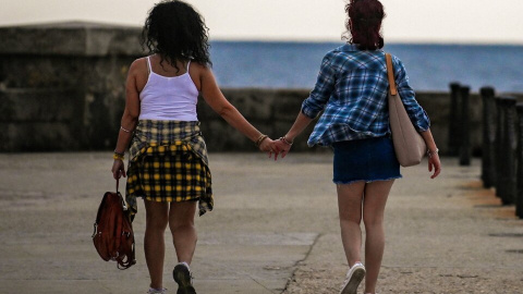 Una pareja andando por Malecón en La Habana