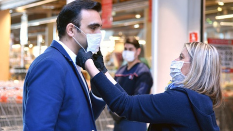 Mujer poniendo ayudando a poner una mascarilla en Austria a principios de la pandemia-01/04/2020