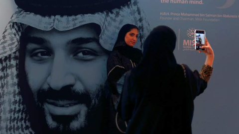 Dos mujeres se fotografían en Riad delante de un cartel gigante con la imagen del príncipe heredero de Arabia Saudí, Mohamed Bin Salman. (FAISAL AL NASSER | REUTERS)