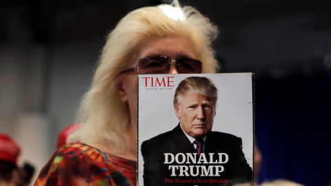 Una seguidora de Donald Trump sostiene una revista con la imagen del presidente estadounidense en portada, en un mitin electoral en Las Vegas (Nevada, EEUU). REUTERS/Mike Segar