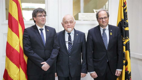 El president de la Generalitat de Catalunya, Quim Torra (d), l'expresident català Carles Puigdemont (i) i el president del Parlament de Flandes, Jan Peumans (c), davant les càmeres moments abans de la reunió celebrada aquest dilluns a la seu d'aquest o