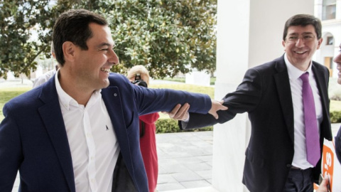 Juan Manuel Moreno Bonilla y Juan Marín se saludan en los pasillos del Parlamento andaluz. /EFE