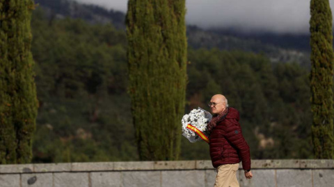 Un hombre con un ramos de flores se dirige a la basílica donde está enterrado Franco. (SUSANA VERA | REUTERS)