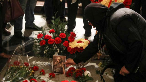 Una mujer coloca una foto de Franco sobre su tumba en el Valle de los Caídos. (REUTERS)