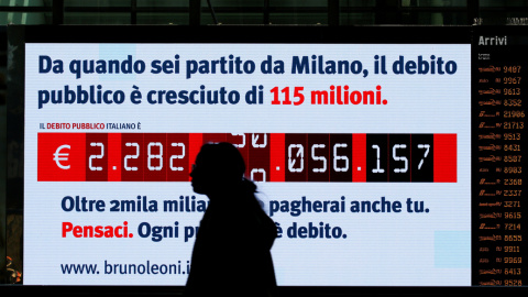 Una mujer pasa frente al llamado 'reloj de la deuda, instalado en la Estación Términi, de Roma, por el Instituto Bruno Leoni, que muestra el crecimiento de la deuda pública de Italia. REUTERS / Alessandro Bianchi