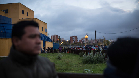 Cientos de solicitantes de asilo esperan la cola durante toda la noche para obtener un cita previa con la que comenzar sus trámites, en la comisaría de Extranjería de Aluche, Madrid. JAIRO VARGAS