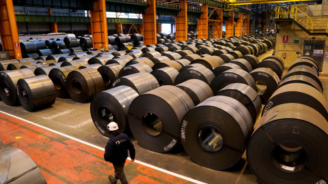 Un trabajador pasa junto a los rollos de acero de la planta de ArcelorMittal en Sestao. REUTERS