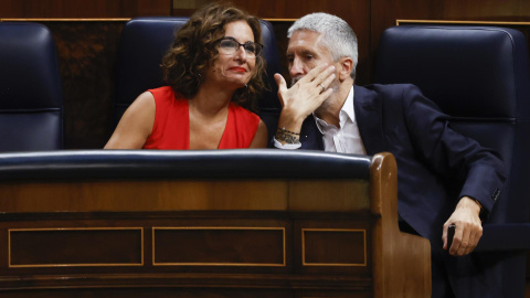 El ministro del Interior, Fernando Grande-Marlaska (d) conversa con la ministra de Hacienda, María Jesús Montero (i) durante la sesión de control al gobierno celebrada este miércoles en el Congreso