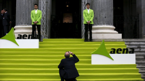 Un hombre saca una foto con su móvil en la entrada de la Bolsa de Madrid, el día en que Aena comenzó a cotizar en el mercado, en febrero de 2015. REUTERS