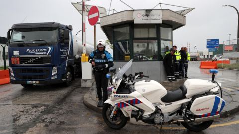 Un camión cisterna es escoltado por un policía a su llegada a la refinería de Leca da Palmeira en Matosinhos, con motivo de la huelga de transportistas de combustible en Portugal. EFE/ Estela Silva