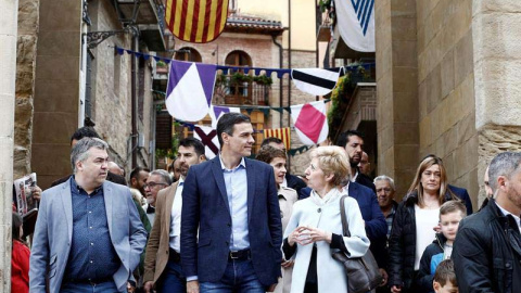 El candidato del PSOE y presidente del Gobierno, Pedro Sánchez, junto a Santos Cerdan (i), y la alcaldesa de Viana Yolanda Gonzalez (d) durante la visita que ha realizado este jueves a la localidad navarra. (JESÚS DIGES | EFE)