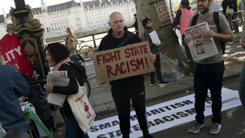 Un asistente a la protesta tras la muerte de Chris Kaba, sostiene una pancarta que insta a combatir "el racismo del Estado" frente a las oficinas de la policía de Scotland Yard en Londres