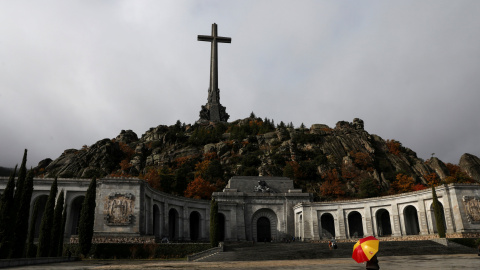 Un hombre con un paraguas con los colores de la bandera española en la explanada de la Basílica del Valle de los Caidos. REUTERS/Susana Vera