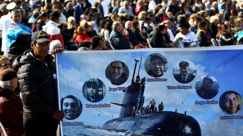 Un hombre sostiene una pancarta con imágenes de algunos tripulantes del submarino argentino ARA San Juan hoy, jueves 15 de noviembre de 2018, durante homenaje al cumplirse un año de su desaparición, en Mar del Plata (Argentina). Los familiares de los 4