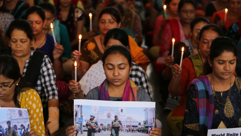 22/04/2019 - Maestros sostienen velas mientras rezan por las víctimas de los atentados en Sri Lanka en una escuela en Ahmedabad, India | REUTERS/ Amit Dave