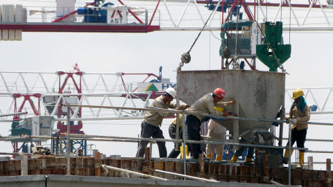 Fotografía de obreros sobre una construcción en horas de trabajo.