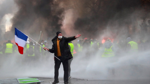 Un manifestante sostiene una bandera francesa durante los enfrentamientos entre los "chalecos amarillos" y la policía en París.- REUTERS/Gonzalo Fuentes