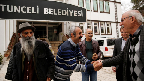 Maçoğlu saluda a varios vecinos junto a un edificio municipal. - REUTERS