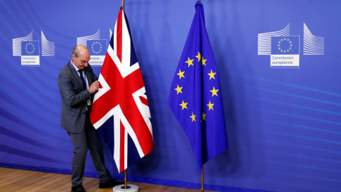 Un empleado de la Comisión Europea coloca la bandera británica.- REUTERS