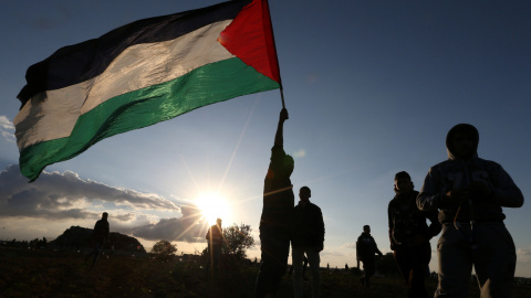 Manifestantes despliegan una bandera de Palestina durante una protesta junto a la frontera en Gaza. - REUTERS