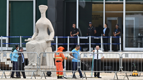 Trabajadores del servicio de limpieza urbana limpian el área cerca a sede de la Corte Suprema en la Plaza de los Tres Poderes este jueves en Brasilia (Brasil).