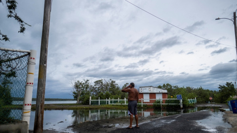 Un hombre examina su vecindario frente al mar mientras el huracán Fiona y sus fuertes lluvias se acercan en Guayanilla, Puerto Rico.