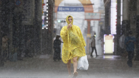 Un hombre camina por la calle bajo fuertes lluvias y vientos causados ​​por el tifón Nanmadol en Kagoshima, en la isla principal más al sur de Japón.