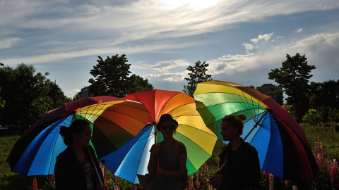 Personas sostienen paraguas arco iris para celebrar el Día Internacional contra la Homofobia frente al edificio del Parlamento rumano en Bucarest. DANIEL MIHAILESCU / AFP