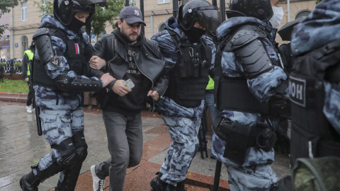 Policías rusos detienen a una persona que participaba en una protesta no autorizada contra la movilización militar parcial de Rusia por el conflicto en Ucrania.