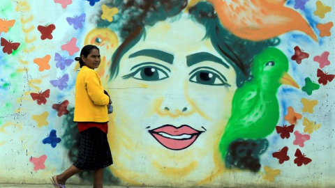 Una mujer camina frente a un mural pintado con el rostro de la ambientalista hondureña asesinada el 2 de marzo de 2016, Berta Cáceres, este jueves en la ciudad de La Esperanza (Honduras). Grupos defensores de los recursos naturales y familiares de Berta