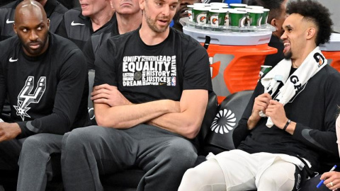 Los jugadores Pau Gasol (C) y Derrick White (d) de San Antonio Spurs conversan este miércoles durante un juego de baloncesto de la NBA ante Detroit Pistons, en San Antonio, Texas (EE. UU.). EFE/ Darren Abate