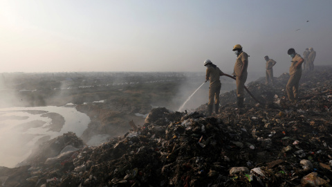 Los bomberos intentan apagar el fuego de la basura quemada en el vertedero de Bhalswa en Nueva Delhi. REUTERS / Altaf Hussain