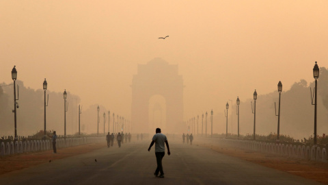 Una persona pasa cerca de la Puerta de la India, cubierta por la polución de Nueva Delhi. REUTERS/Anushree Fadnavis