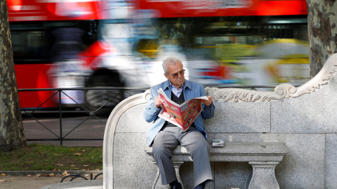 Un pensionista lee el periodico en un banco en el centro de Madrid. REUTERS/Paul Hanna