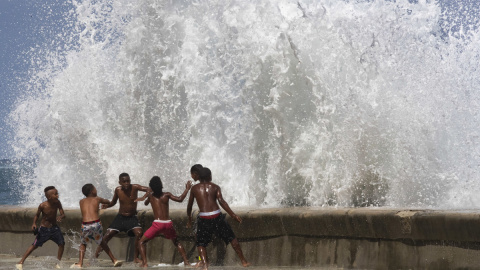 Varios jóvenes se divierten con las fuertes olas, en La Habana, Cuba, a 29 de septiembre de 2022.