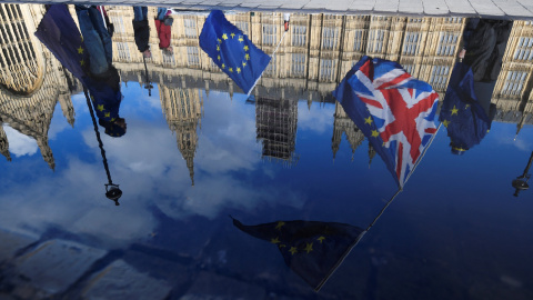 Banderas del Reino Unido y de la UE, reflejadas en un charco de agua frente al Parlamento británico, en Westminster, en una manifestación conraria al brexit. REUTERS/Toby Melville