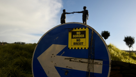 Una pegatina de 'No fronteras, no brexit', en una señal de tráfico frente a la estatua de la Paz titulada 'Hands Across the Divide' en Londonderry, Irlanda del Norte. REUTERS / Clodagh Kilcoyne