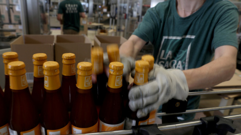 Trabajadores en una línea de embotellado de una fábrica de cerveza, en Madrid. REUTERS/Sergio Perez