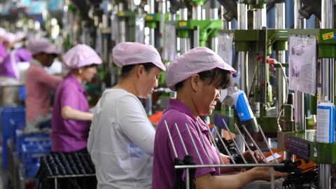 Mujeres trabajadores en una línea de producción de cable de datos en una fábrica en Xinyu, provincia de Jiangxi, China. REUTERS / Stringer