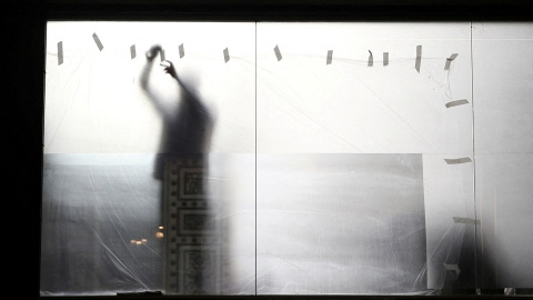 Un trabajador coloca un plástico para proteger el escaparate de un comercio durante unas reformas, en Madrid. REUTERS/Isabel Infantes