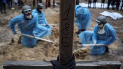 Trabajadores sacan los cadáveres hallados en la fosa común de Izium, a 16 de septiembre de 2022.