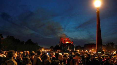 Miles de persona contemplan el incendio de Notre Dame en París. (IAN LANGSDON | EFE)