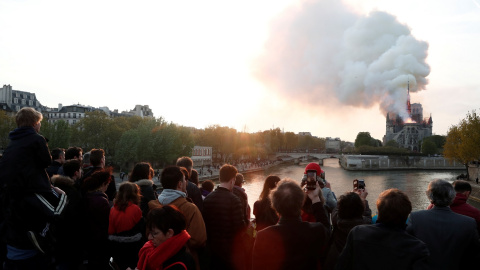 Gente mirando el incendio de la catedral de Notre Dame. Reuters