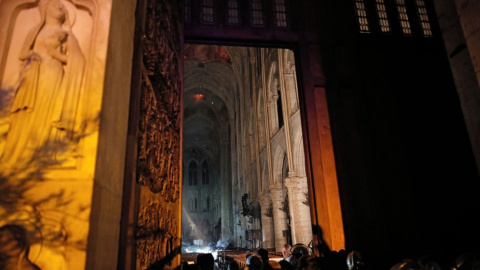 Los bomberos trabajando en el interior de la catedral. / REUTERS