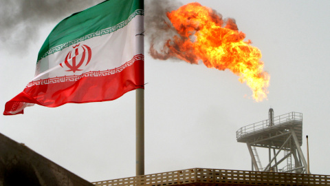 Un bandera de Irán cerca de una llamarada de gas en una plataforma de producción de petróleo en los campos petrolíferos de Soroush, en el Golfo Pérsico. REUTERS / Raheb Homavandi