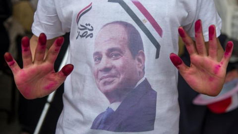 Decenas de personas mostraban banderas nacionales y fotografías del actual presidente egiptcio, Abdelfatah al Sisi, a su salida de un colegio electoral durante la última jornada de votaciones para las elecciones presidenciales. Mohamed Hossam (EFE)