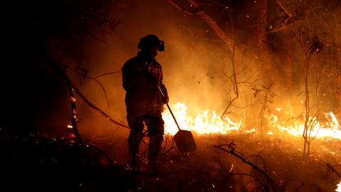 Los bomberos intentan sofocar el incendio en los alrededores de Labares | EFE/ José Luis Cereijido