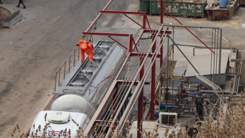 Operarios del polígono industrial de Cartagena equipados con trajes especiales de seguridad.